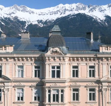 Innsbruck Ultimate Travel Guide Pink Buidling and Mountains